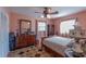 Cozy bedroom with wooden dresser, carpet, and a bed under the window at 10376 Se 43Rd Ct, Belleview, FL 34420