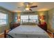 Comfortable bedroom with two windows letting in lots of light, wooden furniture, and a ceiling fan at 10376 Se 43Rd Ct, Belleview, FL 34420