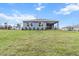 Rear view of the home featuring blue siding, a covered patio, and a grassy lawn at 10512 Sw 49Th Avenue Rd, Ocala, FL 34476