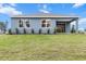 Rear view of the home featuring blue siding, a covered patio, and a grassy lawn at 10512 Sw 49Th Avenue Rd, Ocala, FL 34476