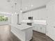 Bright, open kitchen with a large island, white cabinetry, and stainless steel appliances overlooking the living area at 10512 Sw 49Th Avenue Rd, Ocala, FL 34476