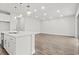 Modern kitchen with white cabinetry, stainless steel appliances, and an open view of a spacious living area at 10512 Sw 49Th Avenue Rd, Ocala, FL 34476