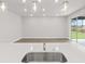 Open floor plan showcasing the kitchen island with a sink and a view into the spacious living area at 10512 Sw 49Th Avenue Rd, Ocala, FL 34476
