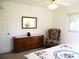 Bedroom showcases a dresser with a mirror and an armchair for a relaxing retreat at 11552 Sw 138Th Ln, Dunnellon, FL 34432