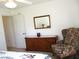 Comfortable bedroom features a cozy chair and a decorative dresser with mirror at 11552 Sw 138Th Ln, Dunnellon, FL 34432