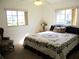 Cozy bedroom with two windows, a floral-patterned bedspread, and a comfortable armchair at 11552 Sw 138Th Ln, Dunnellon, FL 34432