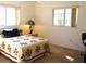 Bright bedroom with natural light features a bed with floral quilt and a cozy bedside lamp at 11552 Sw 138Th Ln, Dunnellon, FL 34432