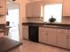 Kitchen sink and cabinets featuring a black dishwasher and tile backsplash at 11552 Sw 138Th Ln, Dunnellon, FL 34432