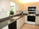 Charming kitchen with white cabinets, dark countertops, and modern appliances at 11552 Sw 138Th Ln, Dunnellon, FL 34432