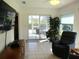 Open living room boasts large television, sliding glass doors, tile floors, and ample natural light at 11552 Sw 138Th Ln, Dunnellon, FL 34432