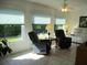 Bright living room featuring tile floors, dual recliners, large windows, and a ceiling fan at 11552 Sw 138Th Ln, Dunnellon, FL 34432