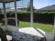 Screened-in patio features an outdoor table overlooking a well-maintained lawn and hedges at 11552 Sw 138Th Ln, Dunnellon, FL 34432