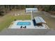 Aerial view of the backyard featuring barn, firepit, pool, and seating area at 13281 Sw 71St Ln, Ocala, FL 34481