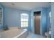 Bright bathroom featuring a large soaking tub and a glass door shower at 13677 Sw 40Th Avenue Rd, Ocala, FL 34473