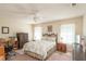 Cozy main bedroom with a ceiling fan, carpet flooring, and an assortment of wooden furniture at 13677 Sw 40Th Avenue Rd, Ocala, FL 34473