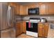 Bright kitchen with stainless steel refrigerator, wood cabinets, and black microwave at 1509 Ne 30Th St, Ocala, FL 34479