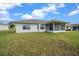 White home exterior featuring a screened-in lanai surrounded by a green lawn at 17799 Se 125Th Cir, Summerfield, FL 34491