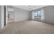 Bright bedroom with a large window, neutral carpet, and view to an adjoining living area at 17799 Se 125Th Cir, Summerfield, FL 34491