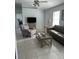 Bright living room featuring tile flooring, a sofa, and a ceiling fan at 17799 Se 125Th Cir, Summerfield, FL 34491