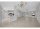 Open-concept living room boasts tile flooring and an elegant chandelier lighting at 17799 Se 125Th Cir, Summerfield, FL 34491