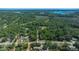 Scenic aerial view of the property showcasing surrounding lush greenery, a pond, and natural landscape at 18434 Se 24Th St, Silver Springs, FL 34488