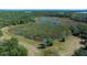 Stunning aerial perspective of a spacious grassy field near a wetland, perfect for outdoor activities at 18434 Se 24Th St, Silver Springs, FL 34488