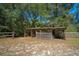 Large animal shelter featuring wooden support beams, slats for ventilation, and a partially covered roof at 18434 Se 24Th St, Silver Springs, FL 34488