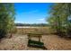 Secluded wooden bench overlooking a beautiful scene of water and trees, promoting relaxation and contemplation at 18434 Se 24Th St, Silver Springs, FL 34488