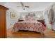 Bright main bedroom with a flamingo patterned bedspread, wood laminate floors, and neutral walls at 18434 Se 24Th St, Silver Springs, FL 34488