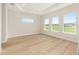 Bright bedroom with tray ceiling, wood floors, and large windows offering plenty of natural light at 1929 Nw 85Th Loop, Ocala, FL 34475
