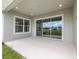 Concrete covered patio with a sliding glass door and window view of the backyard at 1929 Nw 85Th Loop, Ocala, FL 34475