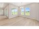 Bright dining area featuring wood floors, modern chandelier, and large windows with scenic views at 1929 Nw 85Th Loop, Ocala, FL 34475