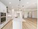 Modern kitchen with white cabinetry, large island, stainless steel appliances, and wood flooring at 1929 Nw 85Th Loop, Ocala, FL 34475