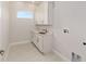 Neat laundry room with sink, white cabinets and tile floor at 1929 Nw 85Th Loop, Ocala, FL 34475
