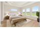 Bright bedroom featuring a tray ceiling, large windows, and a seating area at 1929 Nw 85Th Loop, Ocala, FL 34475