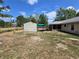 Backyard featuring a storage shed, some grass, screened-in porch, and partial fence at 22 Hemlock Ter, Ocala, FL 34472