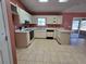 Open kitchen featuring white cabinets and a tile floor, and a sliding glass door to the backyard at 22 Hemlock Ter, Ocala, FL 34472