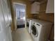 Laundry room with washer, dryer, and storage space with a view into the two-car garage at 22 Hemlock Ter, Ocala, FL 34472