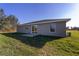 Exterior view of the home with a grassy backyard and a sliding glass door at 2275 Sw 146Th Ct, Ocala, FL 34481