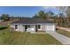 Well-maintained single-story home with gray stucco, lush lawn, and driveway leading to attached garage at 2275 Sw 146Th Ct, Ocala, FL 34481