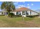 Backyard featuring a sunroom and a lush lawn with manicured landscaping and palm trees at 2399 Nw 53Rd Avenue Rd, Ocala, FL 34482