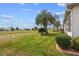Backyard featuring a palm tree, manicured lawn, landscaping, and view of the surrounding neighborhood at 2399 Nw 53Rd Avenue Rd, Ocala, FL 34482