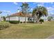 Exterior view of a home showcasing the landscaped backyard with a palm tree and lush green lawn at 2399 Nw 53Rd Avenue Rd, Ocala, FL 34482