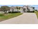 Charming single-story home with a well-manicured lawn, mature landscaping, and a paved driveway at 2399 Nw 53Rd Avenue Rd, Ocala, FL 34482