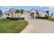 Front exterior of home featuring an attached two-car garage, driveway, manicured lawn, and arched entryway at 2399 Nw 53Rd Avenue Rd, Ocala, FL 34482
