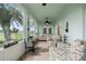 Open and airy sunroom with tile floors, comfortable seating, and large windows showcasing exterior views at 2399 Nw 53Rd Avenue Rd, Ocala, FL 34482