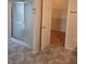 Bathroom features a glass enclosed shower, tile floors, and an open doorway to a walk in closet at 2637 Ne 27Th St, Ocala, FL 34470