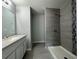 Bathroom featuring modern tiles, a shower, a vanity, and gray walls at 2949 Se 144Th Pl, Summerfield, FL 34491