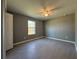 This bedroom features gray walls, gray tiled floors, a ceiling fan, and a window for natural light at 2963 Se 144Th Pl, Summerfield, FL 34491