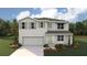 Two-story home with a two-car garage, shutters, and a landscaped yard under a partly cloudy sky at 368 Hickory Course Trl, Ocala, FL 34472